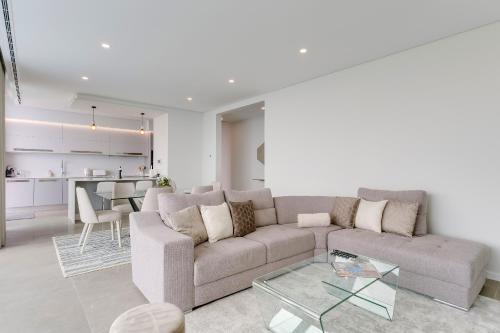 a living room with a couch and a table at Luxury Villa Bianca by Holiday Rental Madeira in Arco da Calheta