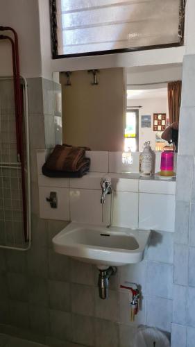 La salle de bains est pourvue d'un lavabo blanc et d'un miroir. dans l'établissement Villa George - Family Holidays, à Nea Makri