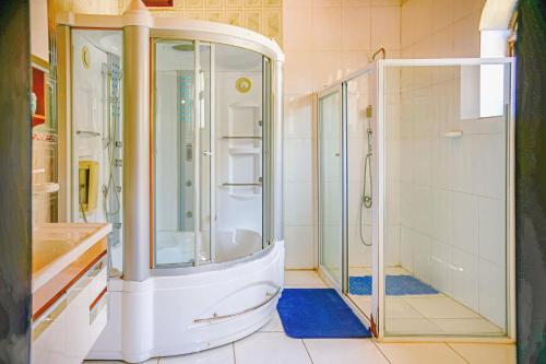 a bathroom with a shower and a glass shower stall at EZRA BOUTIQUE Hotel By The Weekender Ltd in Kigali
