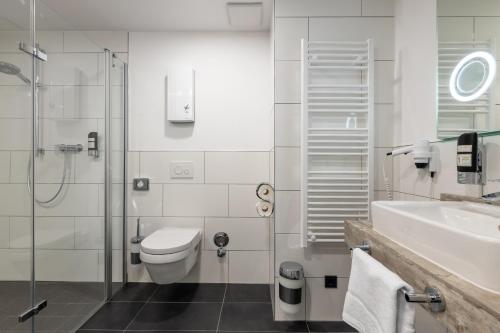 W łazience znajduje się toaleta, umywalka i prysznic. w obiekcie Trip Inn Hotel & Suites Essen w Essen