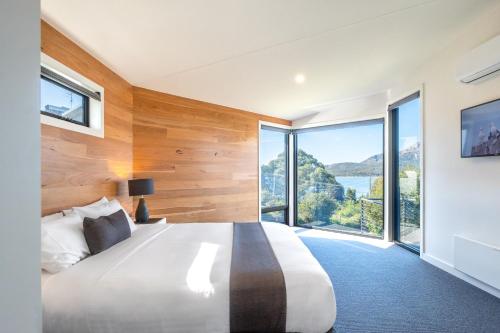 una camera da letto con un grande letto con una grande finestra di At The Bay a Coles Bay