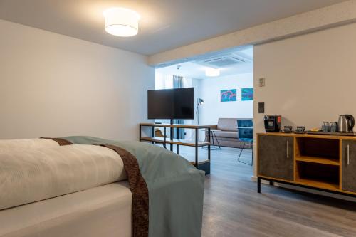 a bedroom with a bed and a tv and a couch at Trip Inn Hotel & Suites Essen in Essen