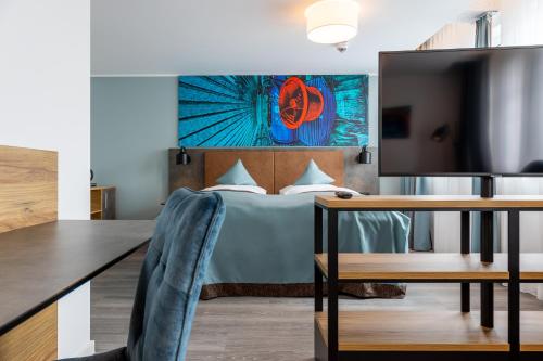 a bedroom with a bed and a desk and a tv at Trip Inn Hotel & Suites Essen in Essen