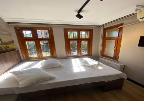 1 cama blanca grande en una habitación con ventanas en Old One, en Estambul