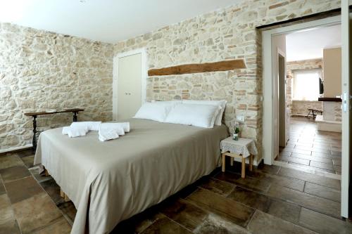 a bedroom with a large bed in a stone wall at Le dimore nel borgo in Pescocostanzo