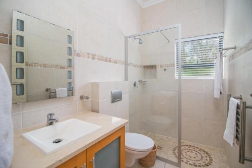 a bathroom with a sink and a toilet and a shower at Pezula Ocean Vista Luxury in Knysna
