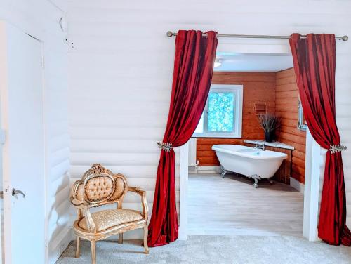 baño con cortinas rojas, bañera y silla en Kaoglen Doe-Feature Bathroom-Cairngorms-Pets Allowed, en Balnald