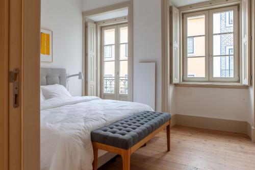 a bedroom with a bed with a bench in it at Charming 2BDR Apartment in Lapa by LovelyStay in Lisbon