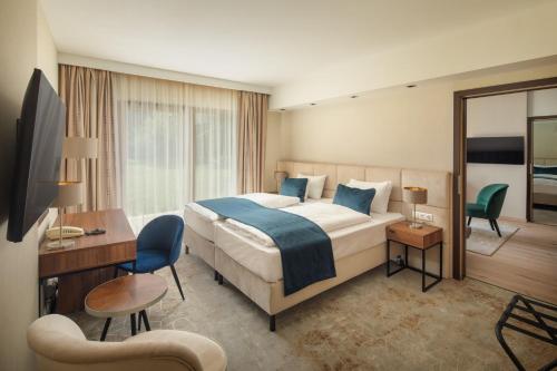 a hotel room with a large bed and a desk at Fagus Hotel Conference & Spa in Sopron