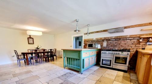a kitchen with a stove and a dining room with a table at Luxury 5-bed Villa - Winfields House in Prestonpans