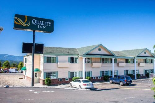 a hotel with cars parked in front of a building at Quality Inn in Grants Pass