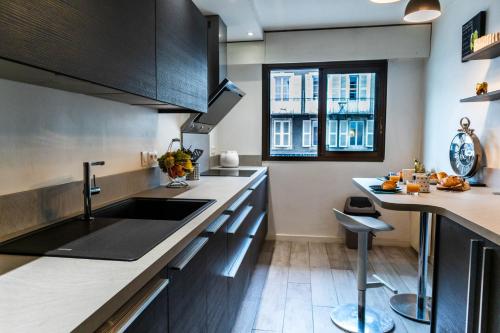 une cuisine avec un évier et un comptoir dans l'établissement Le Sperata - Bel appartement en centre ville avec 2 chambres, terrasse et parking, à Pau