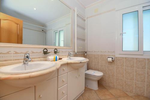uma casa de banho com 2 lavatórios e um WC em Anngo em Xàbia