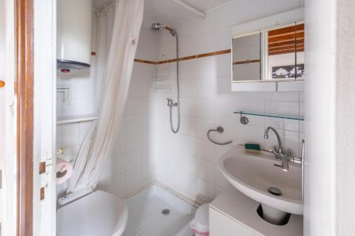een witte badkamer met een wastafel en een toilet bij Maison d'une chambre avec piscine partagee jardin clos et wifi a Villemur sur Tarn in Villemur-sur-Tarn