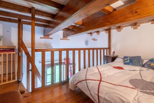 ein Schlafzimmer mit einem Bett in einem Zimmer mit Holzdecken in der Unterkunft Charmante maison à Villemur-sur-Tarn avec piscine partagée in Villemur-sur-Tarn