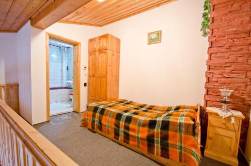 a bedroom with a bed and a wooden wall at Palyongov Guest House in Chepelare