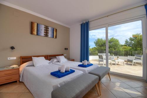 two beds in a bedroom with a view of a patio at Anngo Dos in Jávea