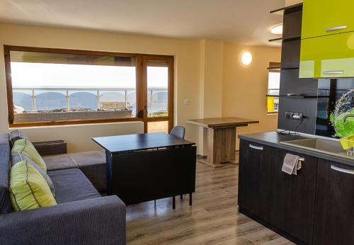 a kitchen and living room with a couch and a table at Spacious 3BD Flat with Large Terrace & Sea View in Varna City