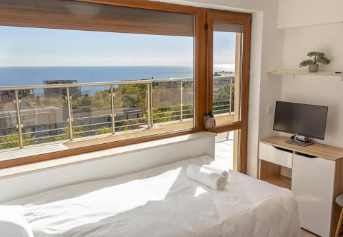 a bedroom with a large window with a view of the ocean at Spacious 3BD Flat with Large Terrace & Sea View in Varna City