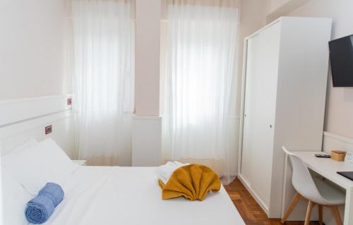 a white bedroom with a white bed and a desk at Emma 12 in Rome