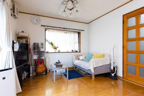 a bedroom with a bed and a window and a guitar at Noriko's Home - Vacation STAY 8643 in Kawasaki