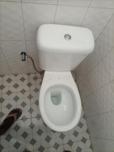 a bathroom with a white toilet in a stall at Pearl Motel Buloba in Buloba