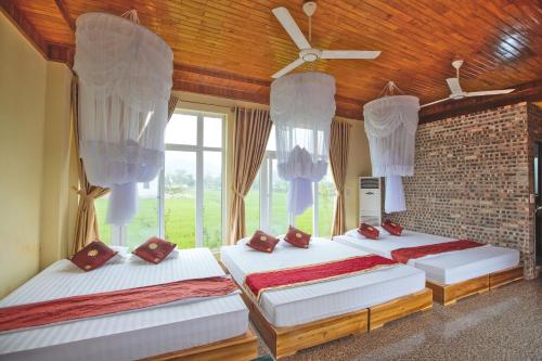 um quarto com 2 camas e uma ventoinha de tecto em Hang Mua Homestay em Ninh Binh