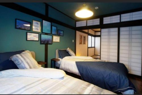 2 camas en una habitación con paredes verdes en 民宿　setouchi en Takamatsu