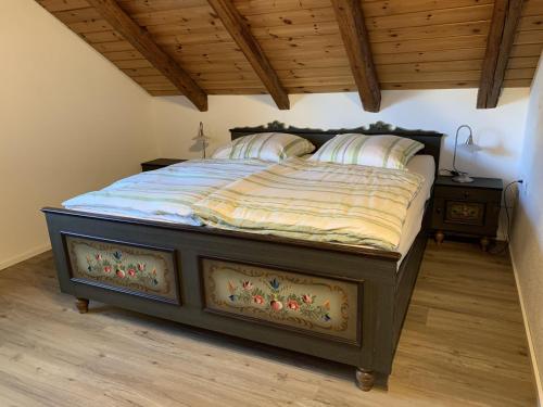 a large bed in a bedroom with a wooden ceiling at Anisers Hüs in Altstädten