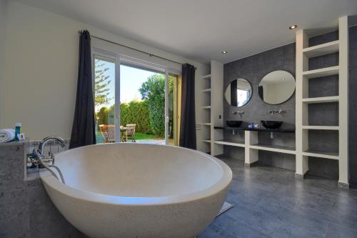 a large bathroom with a large tub and mirrors at Las Marinas 8 in Denia