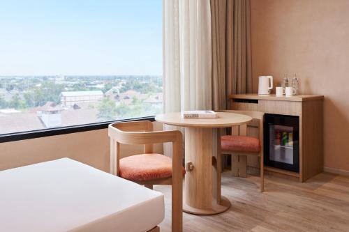 a room with a table and chairs and a window at Centara Korat in Nakhon Ratchasima