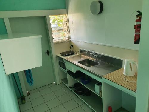 una pequeña cocina con fregadero y ventana en Sunny Beach Lodge en Amuri
