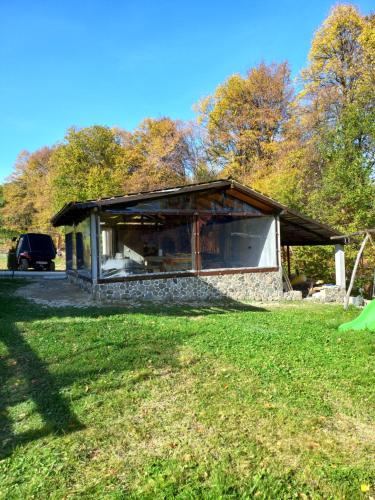 a building on a grass field with a car in the background at Pensiunea Natura Sadu in Sibiu