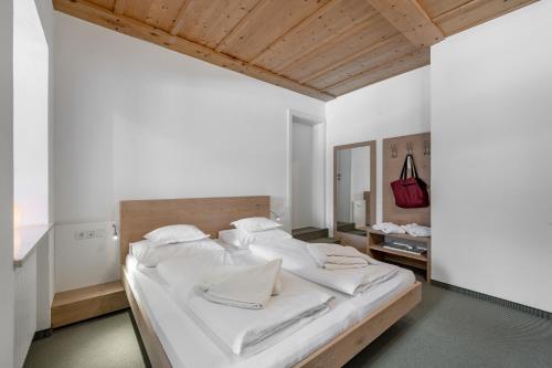 a bedroom with a large bed with white sheets at Hotel Fischer am See in Heiterwang