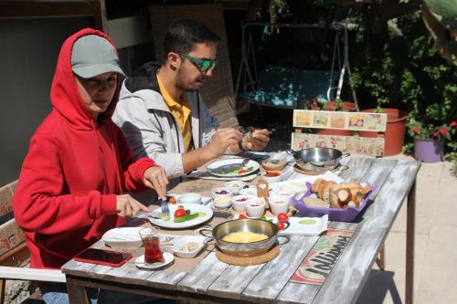 Um homem e uma mulher sentados à mesa com comida. em Eski Datça Pansiyon em Datça