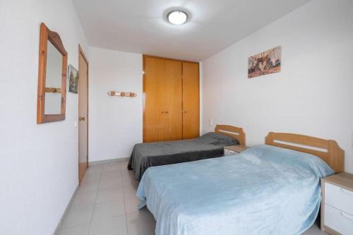 1 Schlafzimmer mit 2 Betten und einem Schrank in der Unterkunft Apartamento en Salou con 3 piscinas junto a Port Aventura in Salou