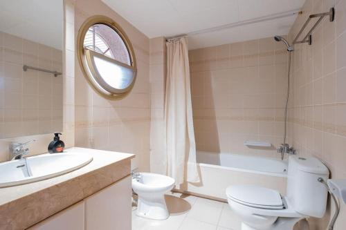 een badkamer met een toilet, een wastafel en een bad bij Apartamento en Salou con 3 piscinas junto a Port Aventura in Salou