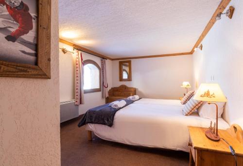 Chalets Les Perdrix - Mountain Collection في لا روزيير: غرفة نوم مع سرير أبيض كبير في غرفة