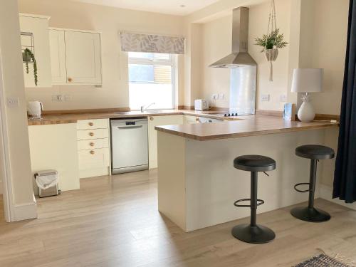 a kitchen with a counter and two bar stools at 1 Ashford Road Guesthouse in Redhill