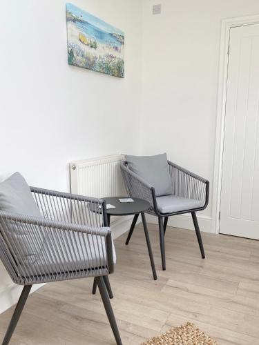 two chairs and a table in a room at 1 Ashford Road Guesthouse in Redhill