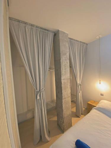 Schlafzimmer mit weißen Vorhängen und einem Bett in der Unterkunft Triana center home in Las Palmas de Gran Canaria