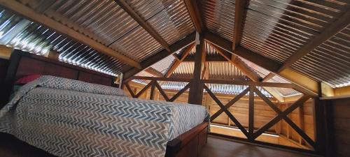 un letto in una stanza con soffitto in legno di Maison Le Bois Joli Coeur a Saint-Benoît