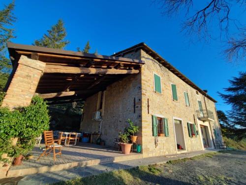 una casa in pietra con veranda e patio. di B&B Demetra a Solignano