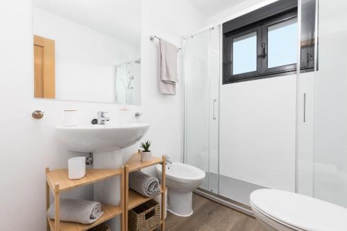 a white bathroom with a sink and a toilet at Villa Maha close by the North shore: relax, pool in Lajares