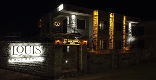 un bâtiment avec un panneau jos sur lui la nuit dans l'établissement Louis Cappadocia, à Uçhisar