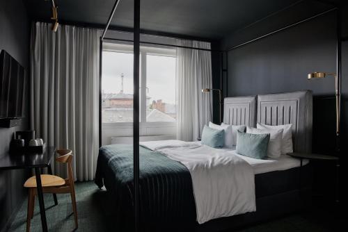 a bedroom with a large bed with a window at Hotel Danmark by Brøchner Hotels in Copenhagen