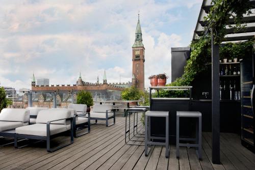 a balcony with chairs and a clock tower on a building at Hotel Danmark by Brøchner Hotels in Copenhagen
