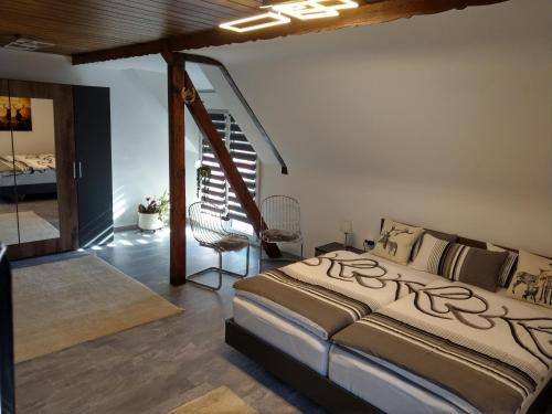a bedroom with a large bed and a staircase at Forsthaus an der Cloef in Mettlach