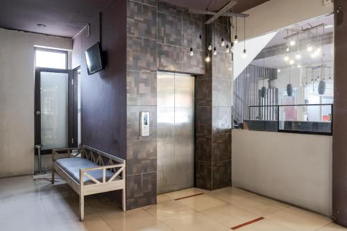 a lobby with a walk in shower with a bench at RedDoorz Plus at Sunrise Hotel Sanur in Sanur