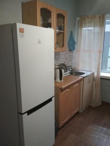 uma cozinha com um frigorífico branco e um lavatório em 1-к. Карасай батыра 110 em Almaty